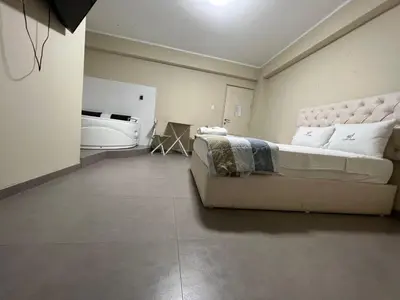 a bedroom with a large bed and a bathroom at Hotel La Suite de Angelique Huacho in Huacho