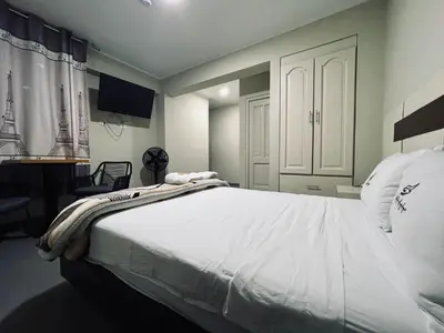 a bedroom with a large bed with white sheets at Hotel La Suite de Angelique Huacho in Huacho