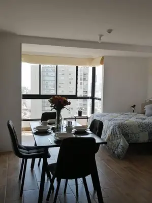 a living room with a table and chairs and a bed at MODERNO LOFT BARRANCO, VISTA PANORAMICA in Lima