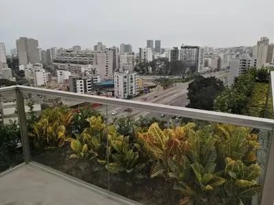 a view of a city from a balcony with plants at MODERNO LOFT BARRANCO, VISTA PANORAMICA in Lima