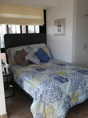 a bed with pillows on it in a bedroom at MODERNO LOFT BARRANCO, VISTA PANORAMICA in Lima