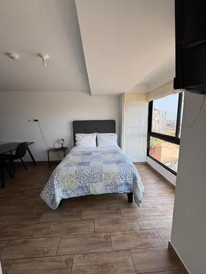 a bedroom with a bed and a large window at MODERNO LOFT BARRANCO, VISTA PANORAMICA in Lima