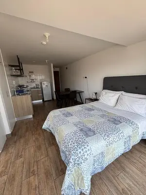 a bedroom with a large bed and a kitchen at MODERNO LOFT BARRANCO, VISTA PANORAMICA in Lima