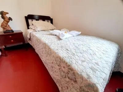 a bedroom with a bed and a table with a night stand at Maypa Lima Airport in Lima