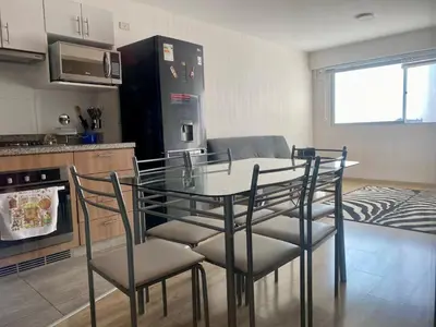 a kitchen with a glass table and chairs in a room at Céntrico mini departamento, moderno y acogedor in Lima
