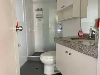 a white bathroom with a toilet and a sink at Céntrico mini departamento, moderno y acogedor in Lima