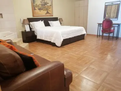 a bedroom with a bed and a living room with a couch at Macacona Hacienda Hotel in Ica