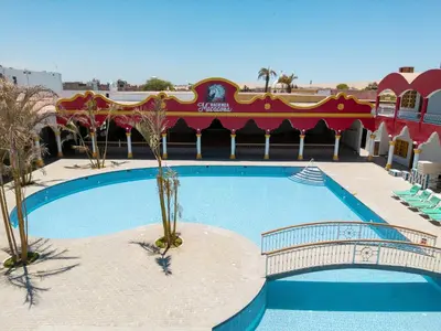 a swimming pool at a resort with palm trees at Macacona Hacienda Hotel in Ica