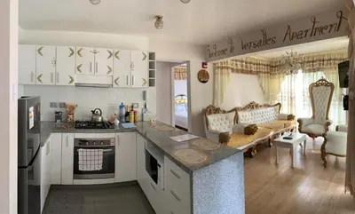 a kitchen with a counter top and a living room at VERSALLES APARTMENT in Lima