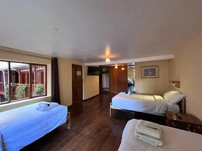a hotel room with two beds and a window at Eco Inn in Cusco
