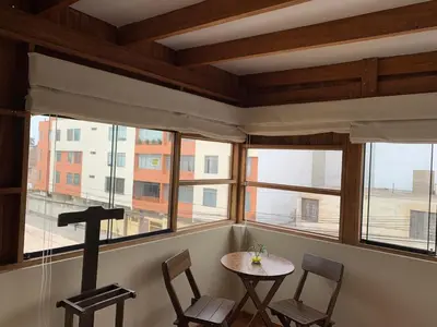 a room with a table and chairs and windows at Apartamento zona histórica Barranco Desayuno incluido in Lima