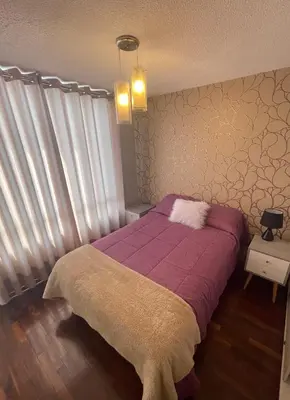 a bedroom with a bed with a purple blanket at Departamento completo en Miraflores Surquillo in Lima