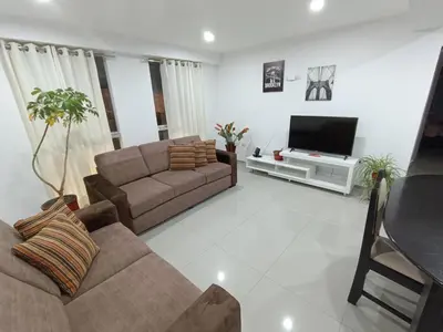 a living room with a couch and a flat screen tv at III Zaguan Aparta Hotel Cusco in Cusco