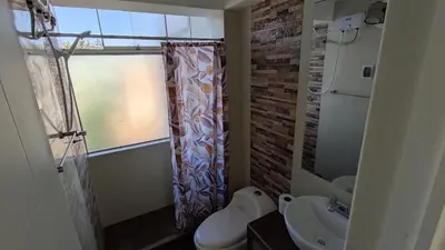 a bathroom with a sink and a toilet and a window at III Zaguan Aparta Hotel Cusco in Cusco