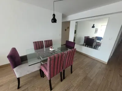 a dining room with a glass table and purple chairs at Espacio Luxury Apartments - Malecón 28 de Julio. in Lima