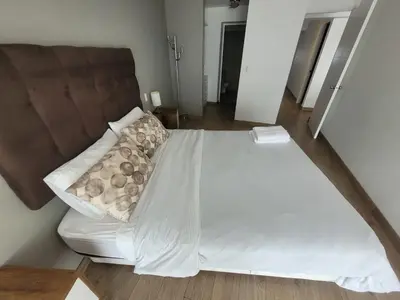 a bedroom with a white bed with a brown headboard at Espacio Luxury Apartments - Malecón 28 de Julio. in Lima