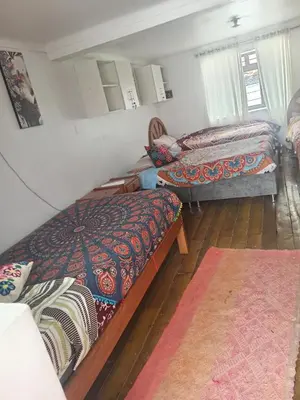 a room with three beds and a rug at Hostel mágico San Blas in Cusco