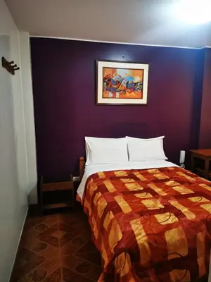 a bedroom with a bed with a purple wall at Los Sauces in Huacho