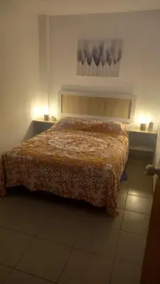 a bedroom with a bed with a blanket on it at Departamentos Cerro Azul P2 in Cerro Azul