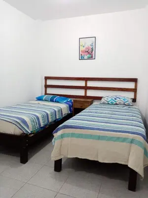 two beds sitting next to each other in a room at Departamentos Cerro Azul P2 in Cerro Azul