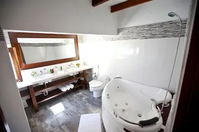 a bathroom with a tub and a toilet and a sink at Hotel & Hacienda El Carmelo in Ica