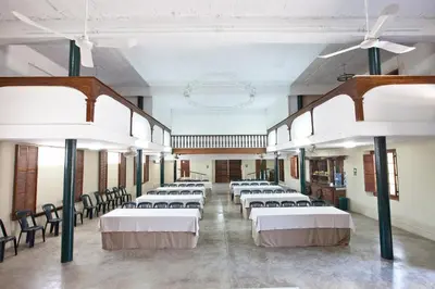 a large room with rows of beds with chairs in it at Hotel & Hacienda El Carmelo in Ica