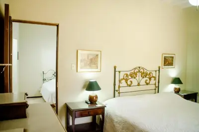 a bedroom with a white bed and a mirror at Hotel & Hacienda El Carmelo in Ica