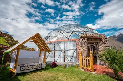 a glass dome house with a bed in the grass at Stardome Spiritual Experience in Ollantaytambo