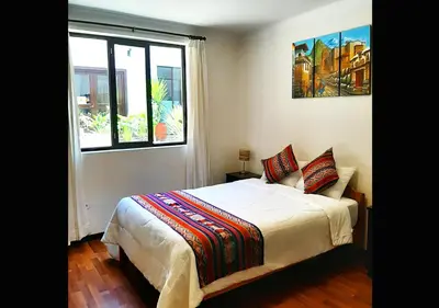 a bedroom with a bed and a large window at Hotel Santa Maria in Cusco