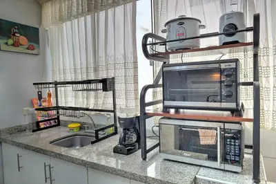 a kitchen counter with a microwave and a sink at Dpto entero, 2do piso, ascensor y cochera in Lima