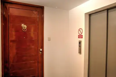 a wooden door in a room with a no smoking sign at Dpto entero, 2do piso, ascensor y cochera in Lima