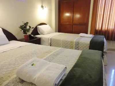 a hotel room with two beds with towels on them at Hotel Torontel in Ica