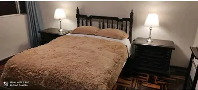 a bedroom with a bed and two lamps on tables at Habitación amoblada independiente dentro departamento amoblado tipo ROOMIE in Lima