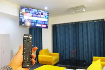 a person holding a remote control in front of a television at Casalos Hotel & Spa in Huancayo