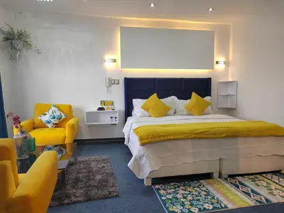 a bedroom with a large bed and a yellow chair at Casalos Hotel & Spa in Huancayo
