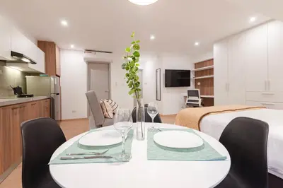 a dining room table with two chairs and a kitchen at ALU Apartments - Miraflores in Lima