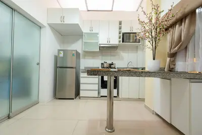 a kitchen with white cabinets and a stainless steel refrigerator at Sweet MATERNITY Home & 3 dormitorios, AIRE ACONDICIONADO in Lima