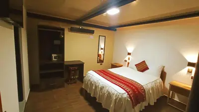a hotel room with a bed and a desk at La Posada del Viajero in Cusco