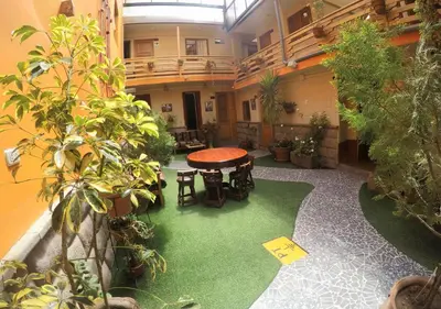 a room with a table and chairs and plants at La Posada del Viajero in Cusco