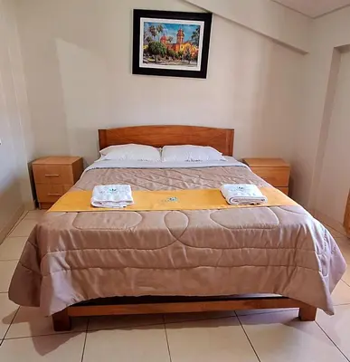 a bedroom with a bed with two towels on it at Illari Wari II-Hotel Sauna in Ayacucho