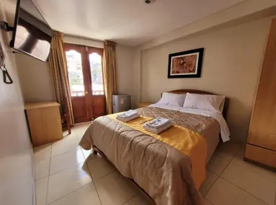 a bedroom with a bed with two towels on it at Illari Wari II-Hotel Sauna in Ayacucho