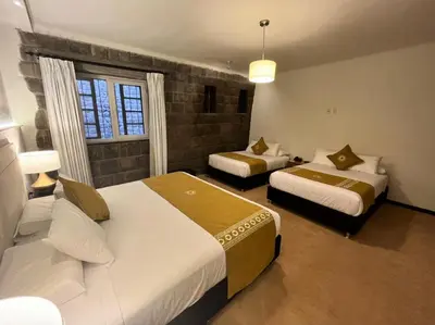 a hotel room with two beds and a window at Katari at Plaza de Armas Cusco in Cusco