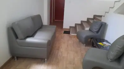 two chairs and a couch in a room with stairs at Hospedaje Margarita in La Merced