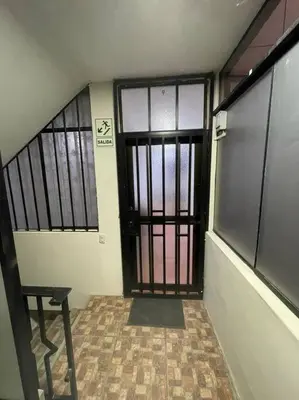 an empty hallway with a door and a gate at Departamento D&C I entero acogedor in Huancayo