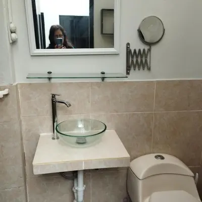 a woman taking a picture of a bathroom sink at Barranco monumental in Lima
