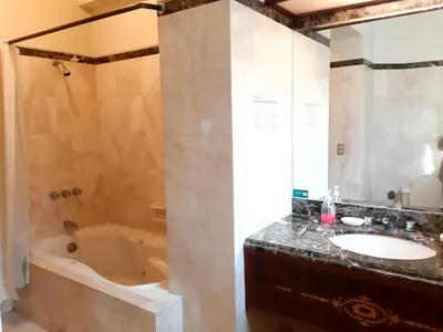 a bathroom with a tub and a sink at Hotel MAURY in Lima