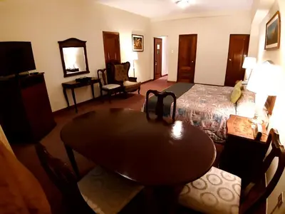 a hotel room with a bed and a table and chairs at Hotel MAURY in Lima