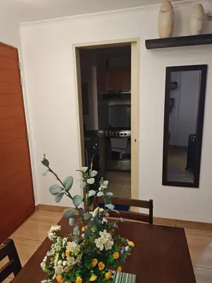 a dining room table with a vase of flowers on it at Dpto PARQUE SAN FELIPE in Lima