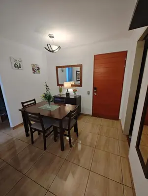 a dining room with a table and chairs and a wooden door at Dpto PARQUE SAN FELIPE in Lima