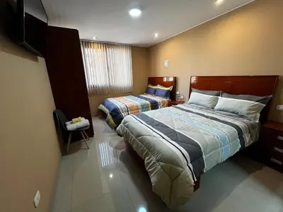 a hotel room with two beds and a flat screen tv at Matty House in Lima